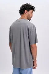 Remera de manga corta oversize color gris claro, con cuello redondo y estampa pequeña frontal con la inscripción "Sailing Club France".