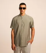 Camisa de manga corta con cuello tipo padre y cierre frontal de botones. Confeccionada en tejido texturizado de mezcla de viscosa y poliamida, con corte slim y acabado fluido.