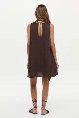 Vestido corto de lino blanco, sin mangas, con cuello redondo y diseño holgado.