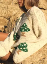 Sweater de lana merino color marfil, tejido a mano con cuello redondo y diseño estampado de hongos verdes y marrones.