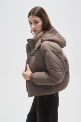 Campera puffer negra con capucha, manga larga, cierre frontal y cuello alto.