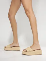Sandalias de plataforma Schutz forradas en yute, estilo chunky, con tira ancha en el empeine y detalle de aplique metálico dorado.