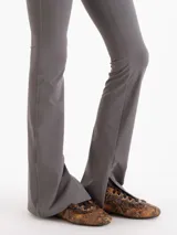 Pantalón Margot de microfibra negra, de tiro alto y silueta ajustada con botamangas acampanadas y tajos laterales.