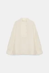 Camisa de manga larga confeccionada en seda 100%, con cuello mao y cierre frontal con botones. Presenta un diseño con bajo asimétrico y puños clásicos.