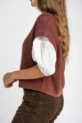 Chaleco sin mangas de tejido de punto color rosado pálido, con textura calada y acabado lurex, corte al cuerpo y cuello redondo.