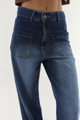 Jean wide leg azul con bolsillos plaqué en el delantero y bajo descosido.