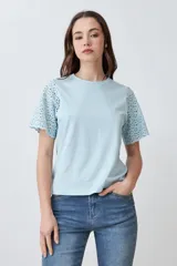 Remera fucsia de manga corta con detalle de broderie en las mangas.