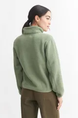 Campera negra de corderito con cuello alto, cierre frontal con cremallera, bolsillo de parche en el pecho y bolsillos laterales.