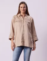 Camisola color beige de tencel, marca Hester & Orchard. Tiene cuello con solapa, escote en V, abertura central con botones y bolsillos delanteros.