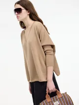 Sweater color beige de hilo con textura brillosa, escote en V y manga larga.