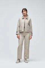 Chaqueta de lana fina sin teñir, con cuello clásico y bolsillos frontales. Presenta detalles bordados en el cuello y en los puños de las mangas. Es una prenda forrada con diseño exclusivo.