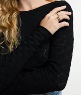 Blusa de manga larga, color blanco, con cuello redondo y textura de punto calado con diseño geométrico.