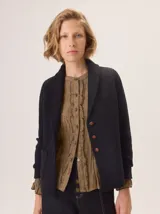 Saco de lana hervida color negro, con cuello solapa, cierre frontal de botones rústicos y bolsillos laterales. Presenta un diseño clásico con coderas y textura artesanal.