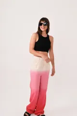 Pantalón sastrero de lino con diseño degradado en tonos beige y rosado, de tiro medio-alto, corte flared y pinzas en la cintura. Cuenta con bolsillos laterales y cierre con trabilla metálica.