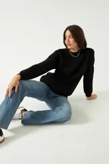 Sweater negro de punto suave con cuello redondo y hombros caídos.