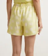 Short recto amarillo con estampado de lunares blancos, cintura alta con cinturón para atar y bolsillos laterales.