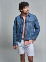 Campera de jean azul de corte regular, con lavado medio, dos bolsillos en la pechera con tapita y dos bolsillos inferiores.