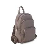 Mochila de tamaño mediano confeccionada en símil cuero color beige, con doble bolsillo frontal con cierre metálico, asa de mano superior y correas regulables de cinta tejida.