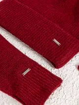 Set de accesorios de invierno en color beige melange, compuesto por un gorro tipo beanie de punto acanalado, un par de guantes de punto y una bufanda de punto con terminación acanalada.