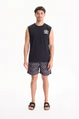 Musculosa negra de algodón, con diseño sin mangas y estampado gráfico blanco en la espalda con texto y números deportivos estilo universitario.