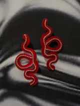 Aros colgantes con forma de serpiente blanca delineada con strass plateado.