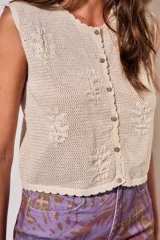 Chaleco de tejido de punto de algodón con diseño texturado de flores, escote redondo y cierre frontal con botones.