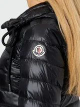 Campera corta de plumas Moncler modelo Jasmin, color negro, con diseño acolchado, cierre frontal y capucha integrada.