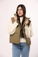 Chaleco puffer de nylon en color verde oliva, con cuello alto, cierre frontal con cremallera y botones a presión, y bolsillos laterales.