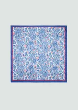 Pañuelo cuadrado con estampado paisley en tonos azules y detalles en rojo, con borde azul y línea roja decorativa.