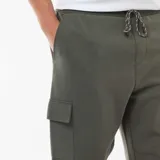 Pantalón cargo color verde militar, con bolsillos laterales tipo cargo, cintura elástica y puños ajustados en los tobillos.