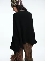 Sweater de tejido de punto color marrón con textura tipo waffle, diseño amplio, hombros caídos y cuello redondo. Presenta un bolsillo frontal aplicado y mangas con puños anchos decorados con botones.