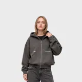 Buzo con capucha y cierre frontal completo, confeccionado en tela Aspen de textura suave. Presenta diseño holgado, bolsillos tipo canguro y detalles estampados minimalistas en el pecho.