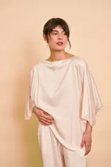 Blusa de satén color beige, con escote bote, corte holgado y mangas amplias tipo kimono.