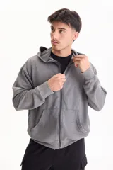 Campera con capucha y cierre frontal, color beige con efecto lavado stone wash, bolsillos tipo canguro y corte oversize.