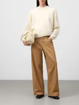 Pantalón de denim color camel con corte barrel fit, pierna ancha y pinza bajo la rodilla. Cuenta con cierre de botón metálico, trabillas para cinturón, cinco bolsillos y canesú en la espalda.