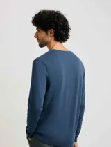 Sweater azul de tejido de punto con escote en V y mangas largas.