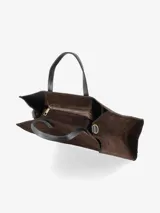 Cartera estructurada de gamuza color marrón oscuro, con doble asa de mano en cuero negro y correa regulable y desmontable en cuero negro con herrajes dorados.