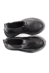 Borcego negro de cuero liso con elásticos laterales y suela de goma.