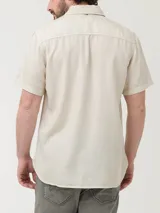 Camisa de manga corta RKF de tencel color marrón claro, con corte regular fit, botones frontales claros, bolsillo en el pecho con el logo del pato bordado al tono y cuello clásico.