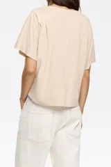 Camiseta negra de corte boxy y escote redondo, con manga corta y logo estampado en el frente.