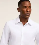 Camisa de corte regular confeccionada en microfibra, con cuello inglés, manga larga y cierre frontal abotonado. Presenta un diseño liso y minimalista, ideal para un estilo formal o de oficina.