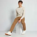 Sweater color beige claro de tejido de punto liso con cuello redondo y mangas largas.