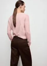Jersey de punto en canalé color rosado, con cuello redondo, manga larga y diseño entallado.