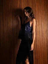 Pollera midi de terciopelo negro con corte asimétrico y detalle de encaje en el ruedo.