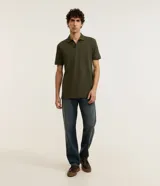 Remera polo de manga corta color verde militar, confeccionada en algodón peruano con cuello convencional y cierre de botones.