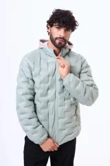 Campera puffer con capucha, color verde menta, con diseño termosellado, cierre frontal y bolsillos laterales.