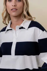 Sweater liviano de estilo rugby con diseño de rayas anchas horizontales en color blanco y verde agua. Presenta cuello polo con cartera de botones, mangas largas y un calce relajado de terminación recta.