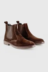 Botas Chelsea de gamuza color marrón, con paneles elásticos laterales y suela de cuero con vira pespunteada.