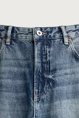 Jeans flare fit de hombre confeccionados en denim de algodón color azul con efecto lavado y roturas. Presentan diseño de cinco bolsillos, efecto salpicaduras de pintura en toda la prenda y bajo con acabado irregular.