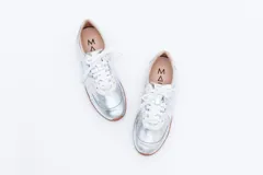 Zapatillas Magnolia de cuero negro con detalles en blanco y suela marrón.